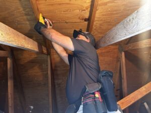 Licensed Florida home inspector examining roof rafters during a four-point insurance inspection