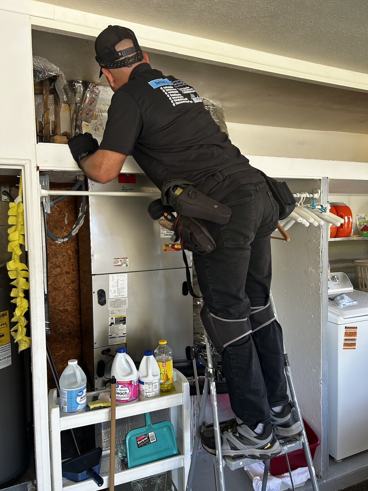 Home inspector checking an HVAC air handler in a garage during a Florida home inspection